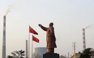 Smoke comes out of the chimneys of Wuhan Iron and Steel Corp. in Wuhan, Hubei Province, where a statue of Mao Zedong stands.