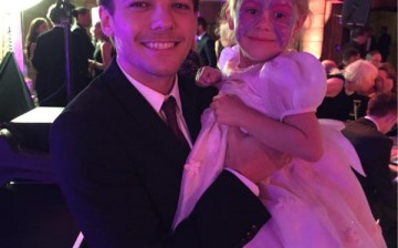 One Direction's Louis Tomlinson carries Eleanor Stollery, a girl  with brain tumour who had lost her eyesight, during the recent Believe in Magic Charity Ball.