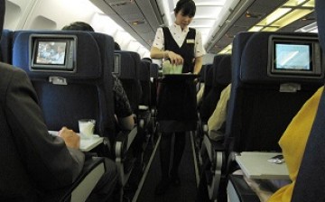 An attendant of a Chinese airline serves passengers in a flight. According to reports, cases of bad behavior against airline staff have increased recently.