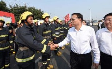 A firefighter shakes hands with Premier Li Keqiang during the Chinese leader's visit in Tianjin on Sunday, Aug. 16.