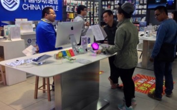 Customers look at Apple iPhones at a mobile store in China.