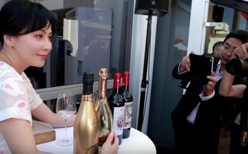 Carina Lau poses with her wines and champagnes in an event in France.