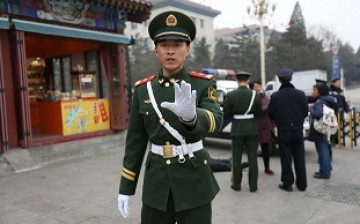 A policeman stops a vehicle at a checkpoint in Beijing.