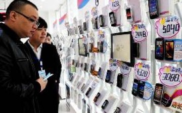 Buyers look at smartphones on display at a China Mobile Ltd. store in Zhengzhou, Henan Province.
