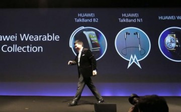 Huawei chief executive Richard Yu walks past his presentation on Huawei's wearable collection.