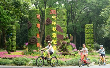 Kids ride bikes around various plants at the botanical garden in Hangzhou, southeast China's Zhejiang Province, on Aug. 30, 2015. 