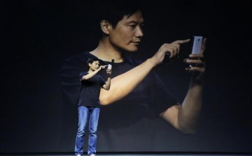 Lei Jun, founder and CEO of China's mobile company Xiaomi, shows the new features at a launch ceremony of Xiaomi Phone 4, in Beijing, July 22, 2014.