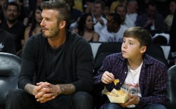Soccer star David Beckham (L) and his son Brooklyn watch the Los Angeles Lakers play the Denver Nuggets during Game 1 of their first round NBA Western