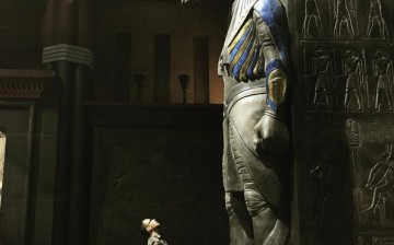 Bryan Singer looks up at a statue of an Egyptian god. 