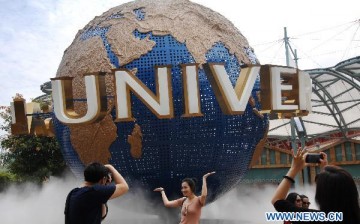 Tourists pose for photos at Universal Studios Singapore, May 30, 2011.