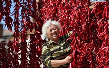 A woman dries red pepper in a yard in Jinlin City, northeast China's Jilin Province.