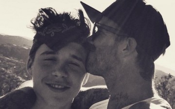 Soccer icon David Beckham plants a kiss on the forehead of his eldest son Brooklyn during one of their outdoor bonding moments.