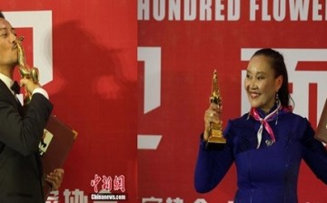 Zhang Hanyu and Ba Dema pose for pictures with their trophy during the 24th Golden Rooster and Hundred Flowers Film Festival in Jilin Province.