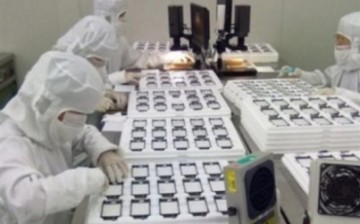 Workers inspect products at an Apple assembly plant in China.