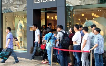Chinese tourists line up outside an overseas Hermes store.