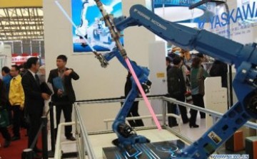 Visitors look at  industrial robots displayed during the 2012 China International Industry Fair in Shanghai. 