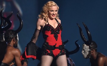 Madonna smiles as she bares more skin during a performance.