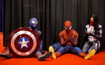 Attendees dressed as Marvel's Captain Spidey, left, Spiderman, center, and Silk take a break during the D23 Expo 2015 in Anaheim, California, U.S., on Friday, Aug. 14, 2015.