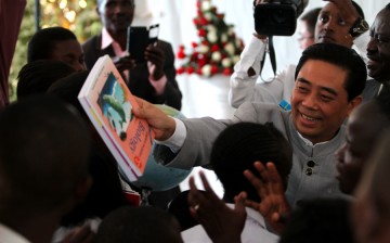 Lu Junqing, chairman of the China-Africa Project Hope, hands books to Hope School students in Nairobi, Kenya, Sept. 30, 2015.