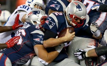 New England Patriots quarterback Tom Brady (#12) carries the ball for a first down during the 2014 AFC Championship game.