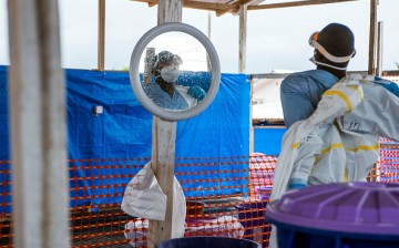 A healthcare worker removes his Personal Protective Equipment (PPE) at an Ebola Treatment Center in Coyah, Guinea, on Thursday, Sept. 10, 2015.
