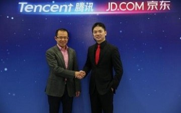 Martin Lau, president of Tencent, and Richard Liu of JD.com shake hands during the announcement of their strategic partnership in e-commerce in March.