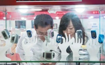 Visitors look at the smart bands and wearable devices displayed at an information technology expo in Shenzhen.
