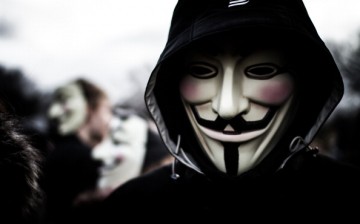 A person wears a Guy Fawkes mask which today is a trademark and symbol for the online hacktivist group Anonymous. 2012.