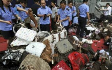Chinese law enforcers sort out counterfeit bags seized in a crackdown in Shanghai.