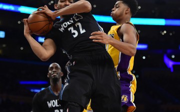 Karl Anthony-Towns grabs the rebound against D'Angelo Russell.