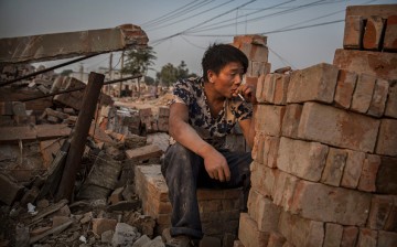 A Chinese laborer smokes as he takes a break in Gucheng Village, Tongzhou District, Beijing, on Oct. 15, 2015. 