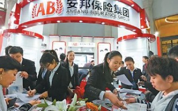 Staff members of Anbang Insurance Group Co. Ltd. explain their policies to prospective clients at an international finance expo in Beijing. 
