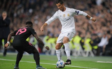 Real Madrid forward Cristiano Ronaldo (R) makes a move against a Paris Saint-Germain defender.