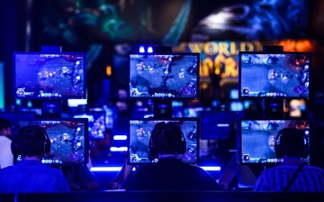 Visitors try out the massively multiplayer online role-playing game 'World Of Warcraft' at the Blizzard Entertainment stand at the Gamescom 2015 gaming trade fair during the media day on August 5, 2015.