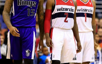 Kings center DeMarcus Cousins (L) with Wizards' John Wall (#2) and Trevor Ariza during a regular season game.