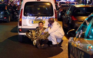 A medic tends to a man near the Boulevard des Filles-du-Calvaire after an attack in Paris, France, on Nov. 13, 2015.