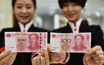 Two employees of China Citic Bank's Hangzhou branch on Thursday present a new version of the 100-yuan bank note (left) alongside the current one.