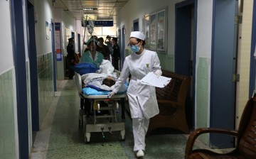A nurse wheels a patient along a hospital hallway in Nanning, Guangxi Province, on Nov. 27, 2014.