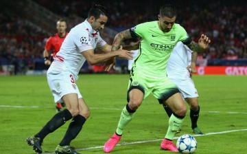Sevilla defender Adil Rami (L) competes for the ball against Manchester City's Aleksandar Kolarov.