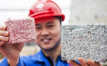 A worker shows a brick made from the ashes of burned old and damaged currency notes. 