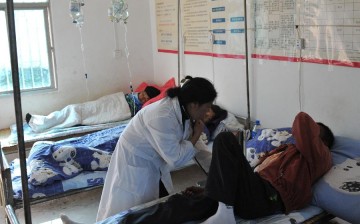 A doctor helps a patient at a clinic in Guangsong Village of Dai-Jingpo Autonomous Prefecture of Dehong, southwest China's Yunnan Province, Nov. 17, 2011.