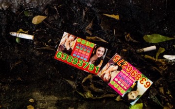 Calling cards litter the ground outside a casino in Macau on July 29, 2013.