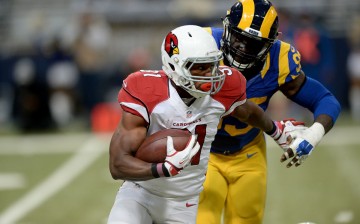 Arizona Cardinals running back David Johnson (#31) carries the ball while under pressure from St. Louis Rams' Aaron Donald.