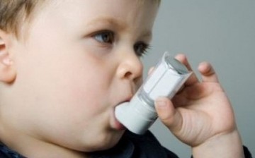 A child uses an asthma inhaler.