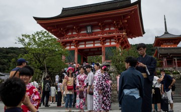 Tourists dressed in traditional Japanese outfits pose for photographs in front of the Kiyomizu Temple in Kyoto, Japan, on Sept. 7, 2015.