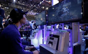 An attendee plays the 'Bloodborne: The Old Hunters' video game, developed by FromSoftware Inc., on a Sony Corp. PlayStation 4 (PS4) game console at the Tokyo Game Show 2015 at Makuhari Messe in Chiba, Japan