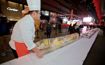 Workers carry a 21-meter-long cake for charity sale at a hotel during the lighting ceremony for 2015 Christmas in Shenyang, Liaoning Province, on Nov. 27, 2015.