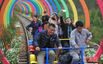 Tourists ride rail bikes on the transformed rail track.