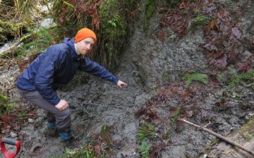 UW graduate student Sean LaHusen pointing to buried debris at an older slide on the north fork of the Stillaguamish River.