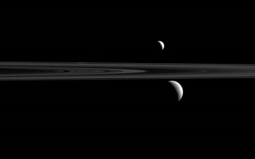 Saturn's rings along with its trio of moons, Rhea, Enceladus and Atlas.